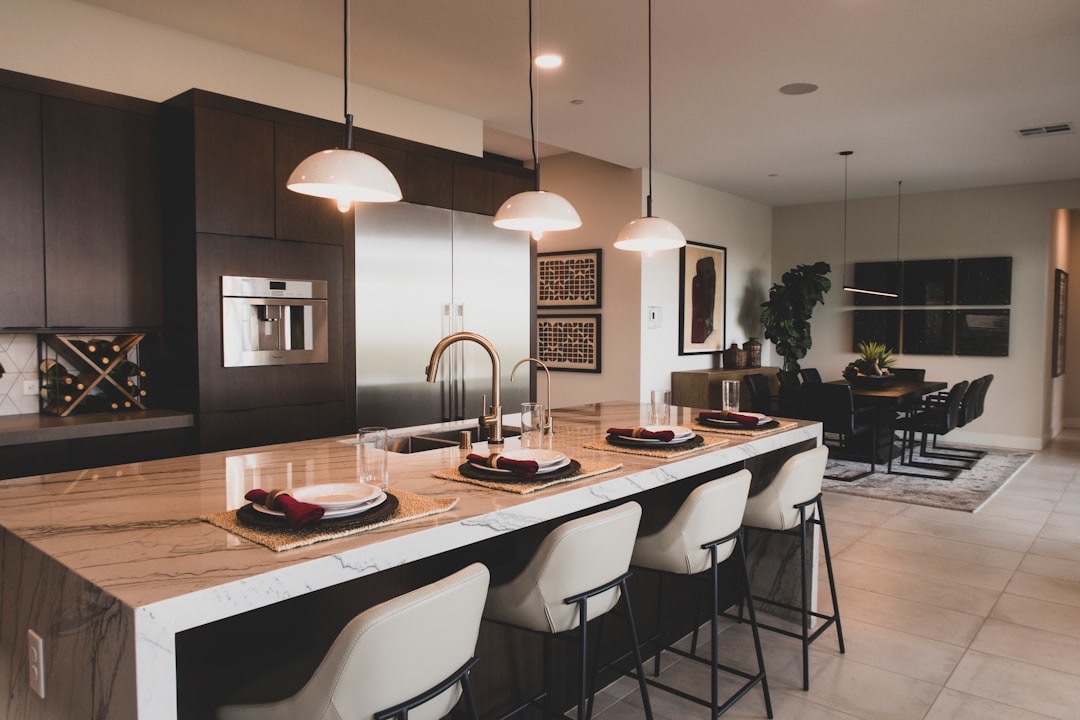 Modern kitchen island with bar stools and dining area.