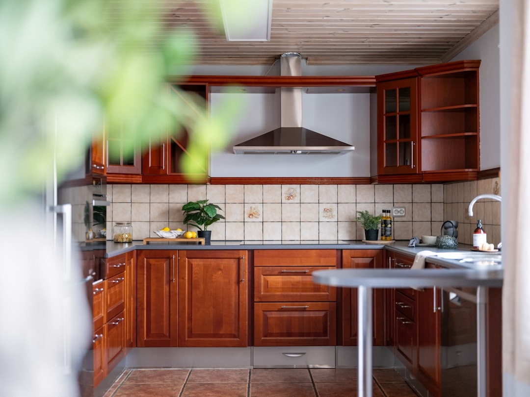 Kitchen featuring wooden cabinets, tiled backsplash, and stainless steel hood.